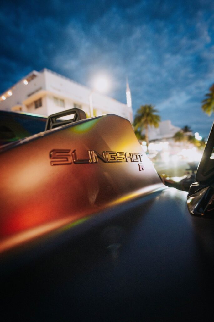 Close-up of the Slingshot badge on the bodywork at sunset