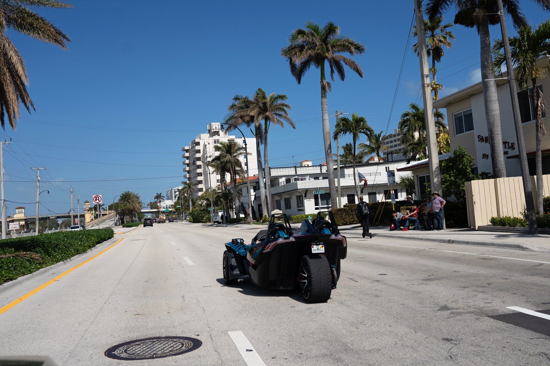 A Polaris Slingshot driving down the palm-lined A1A in South Florida