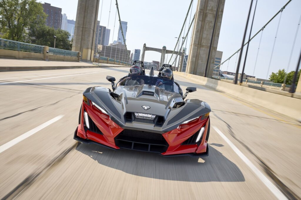 A Polaris Slingshot driving head-on over a South Florida bridge