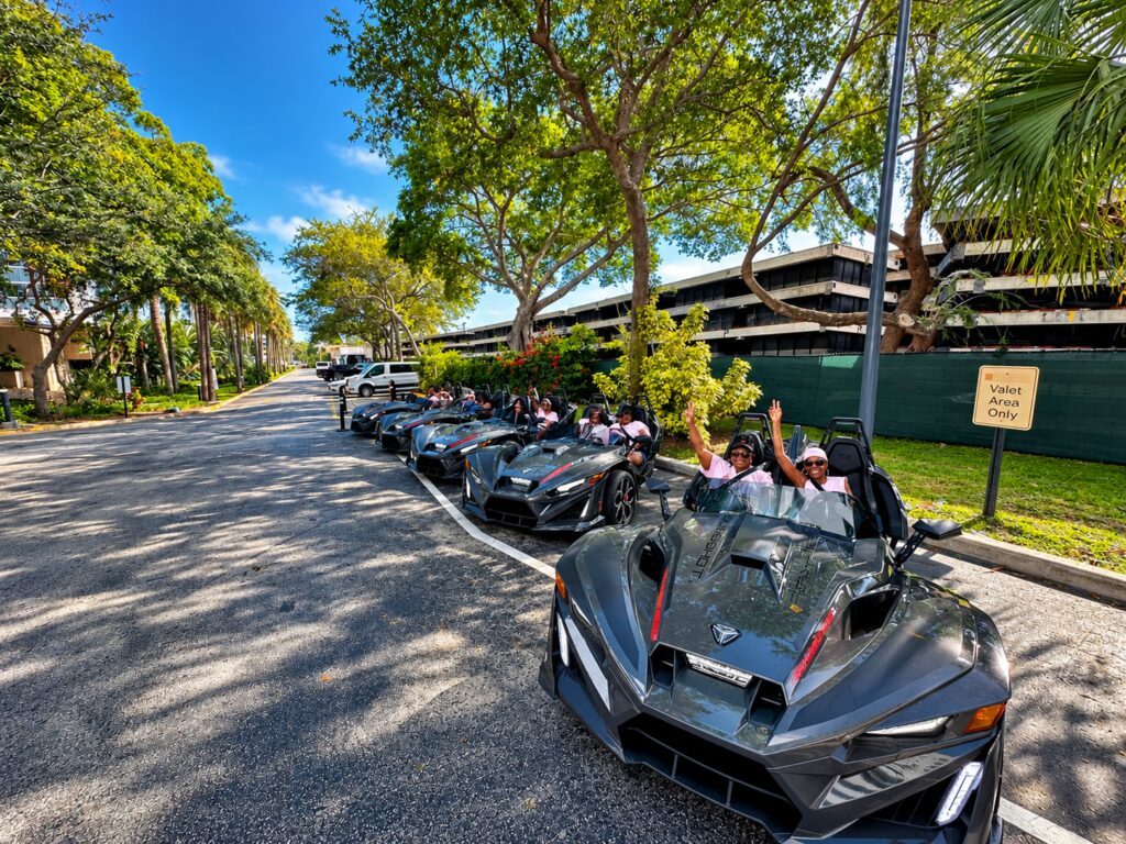 A convoy of Polaris Slingshots on a tree-lined South Florida road